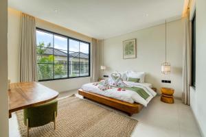 Anjuna Surf & Sunset 2BR Villas in Uluwatu في أُلُواتو: غرفة نوم بها سرير ومكتب ونافذة +32 صورة