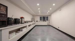 a large kitchen with white walls and a long hallway at Green Tree Inn Express Heze University Town in Heze