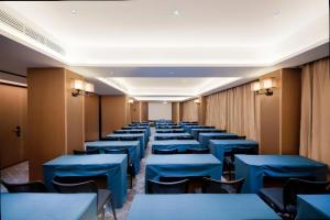 a row of tables and chairs with blue tables at Echeng Hotel Hezhou Shizheng Square in Wuzhou