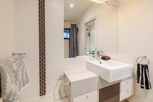 a white bathroom with a sink and a mirror at Pet Friendly, Flex Check-InOut, Australiana Touch in Geelong West +23 photos