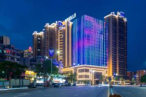 a lit up building in a city at night at Poltton International Service Apartment Haifeng in Shanwei