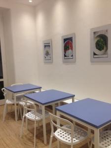 a room with tables, chairs, and tables with pictures on them at Grand Hostel Manin in La Spezia