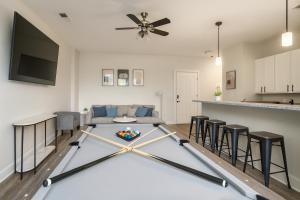 a living room with a table in the middle of a room at Family Group Retreat 3 Queens Beds in Homewood