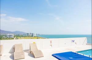 two chairs and a swimming pool on a balcony at Apto Premium con vista al Mar en Pozos Colorados in Playa Bello Horizonte