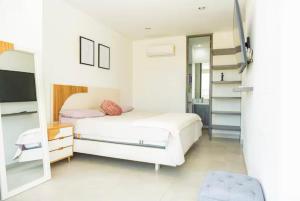 a white bedroom with a bed and a mirror at Apto Premium con vista al Mar en Pozos Colorados in Playa Bello Horizonte +20 photos
