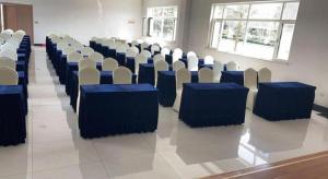 a room with rows of chairs with blue tables at Vienna Hotel Shandong Qingdao Jiaodong International Airport Hai'er Avenue in Qingdao