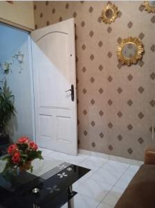 Zimmer mit einer Tür, einem Tisch und einem Spiegel in der Unterkunft POTT Homestay in Godean