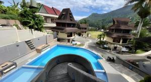a resort with a swimming pool in front of a building at Sapadia Hotel Parapat in Parapat