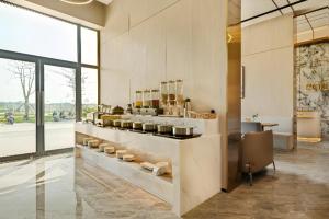 a kitchen with a counter with pots and pans at Poltton International Service Apartment Shanwei Urban District High-speed Railway Station in Shanwei +79 photos