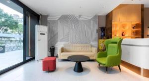 a living room with a couch and a table and chairs at Borrman Hotel Wuhan Hankou Railway Station Metro Station in Wuhan +142 photos