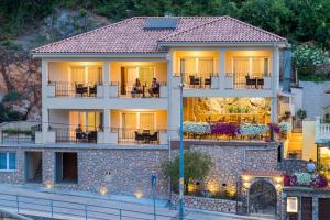 a house with people sitting on the balconies of it at Luksuzne sobe Luce in Vrbnik