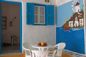 a table with a bowl of fruit on it in a room at Miltiadis Apartments in Ambelas