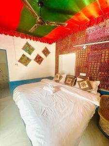 a bedroom with a large white bed in a room at Mirvana Guest House & Camel safari in Jaisalmer