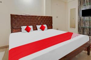 a bedroom with a large bed with red pillows at Super Hotel O Home Town in Patna