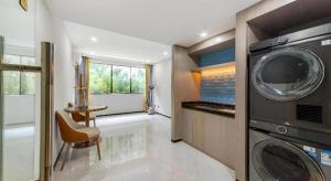 a laundry room with a washing machine and a chair at Echarm Hotel Zigong Machishui Wanda Plaza in Zigong
