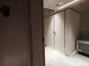 Habitación con armario y puerta. en Echarm Hotel Wuhan Gaotie Jianshe 2nd Road Metro Exit, en Wuhan