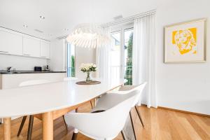 une salle à manger blanche avec une table blanche et des chaises blanches dans l'établissement DESIGN APARTMENT 1 !Gratis parken, Free Parking!, à Kreuzlingen