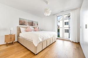 une chambre blanche avec un grand lit et une fenêtre dans l'établissement DESIGN APARTMENT 1 !Gratis parken, Free Parking!, à Kreuzlingen 8 autres photos