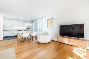 - un salon avec une grande télévision et une table à manger dans l'établissement DESIGN APARTMENT 1 !Gratis parken, Free Parking!, à Kreuzlingen