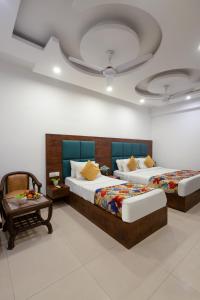 1 dormitorio con 2 camas, mesa y techo en Hotel Krone Chanakyapuri, en Nueva Delhi