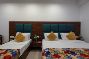 Dos camas una al lado de la otra en una habitación. en Hotel Krone Chanakyapuri, en Nueva Delhi 9 fotos más