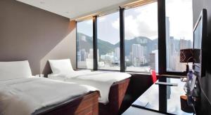 une chambre d'hôtel avec deux lits et une grande fenêtre dans l'établissement J Link Hotel, à Hong Kong