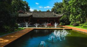 a swimming pool with a fountain in front of a building at Borrman Hotel Chongqing Bishan Central Street in Chongqing