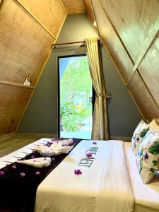 a group of beds in a room with a window at River Nest Hostel in Kampot
