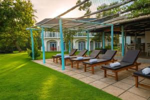 a group of chairs sitting on a patio in a yard at Solara Beach House in Tangalle