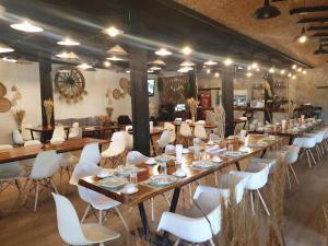 a large room with tables and white chairs at River Kwai Village Hotel in Ban Kaeng Raboet