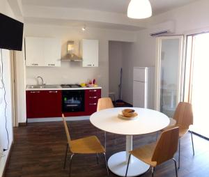 a kitchen and dining room with a table and chairs at Appartamento Il Pomodoro in San Vito lo Capo +26 photos