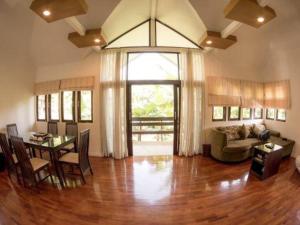 a living room with a table and a couch at Baan Suan Nuan Ta in Samut Songkhram