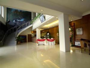 ポンティアナックにあるGaruda Hotel Pontianakの階段と赤い椅子のあるロビー