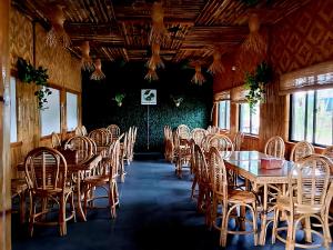 a dining room with wooden tables and chairs at NATIVO D' KUBO in San Vicente