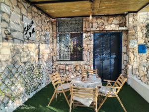 a table and chairs in front of a stone wall at Seleucia DaR Umm Qais in Um Qeis +28 photos