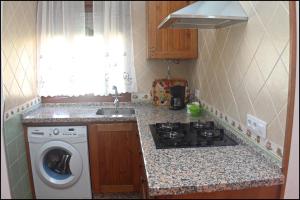 cocina con lavadora y fregadero en Chalet Vigía 114, en Conil de la Frontera