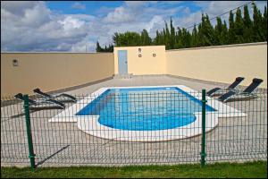 una piscina con sillas frente a un edificio en Chalet Vigía 114, en Conil de la Frontera