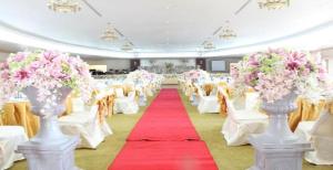 a banquet hall with white chairs and pink flowers at Daosavanh Resort & Spa Hotel in Savannakhet +187 photos