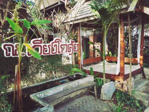 un lit devant un bâtiment dans un jardin dans l'établissement Ruen Kaew Resort, à Phrae