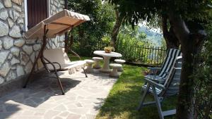 eine Terrasse mit 2 Gartenstühlen und einem Tisch in der Unterkunft Il pozzo in Marone