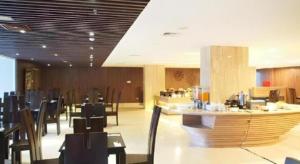 a restaurant with tables and chairs and a bar at Arch Hotel Bogor in Bogor