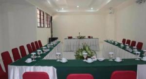 a room with a green table and red chairs at Hotel Griyadi Kusuma Sahid in Solo