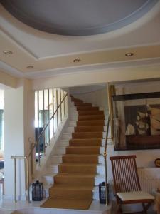 a spiral staircase in a living room with a chair at Villa Faidra in Eretria