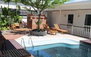 a swimming pool with a tree in a yard at Baan Pimpisa in Pattaya Central