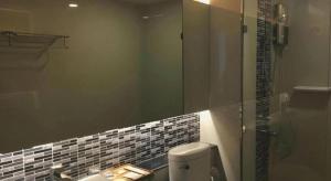 a bathroom with a shower and a toilet and a mirror at Chaisaeng Villa in Sing Buri +156 photos
