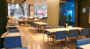 a restaurant with tables and chairs in a room at Jinjiang Inn Yueyang Railway Station in Yueyang