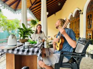 two men sitting at a table playing guitar at The 489 Residence in Negombo