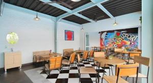 a restaurant with tables and chairs in a room at Umah Bali Suites in Denpasar