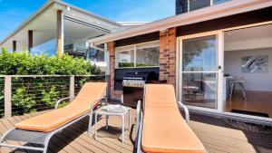 a house with a deck with chairs and a grill at Aquavista Beach, Lake, Sun, and Sand in Budgewoi