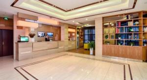 a lobby with a library with a person standing in it at GreenTree Inn Hangzhou Linan Wanma Road Express Hotel in Hangzhou